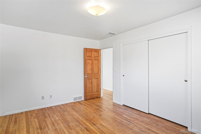 unfurnished bedroom featuring light hardwood / wood-style flooring and a closet