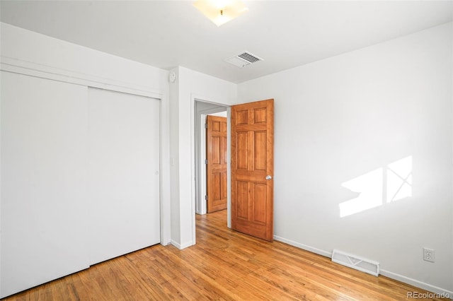 unfurnished bedroom featuring light wood-type flooring and a closet