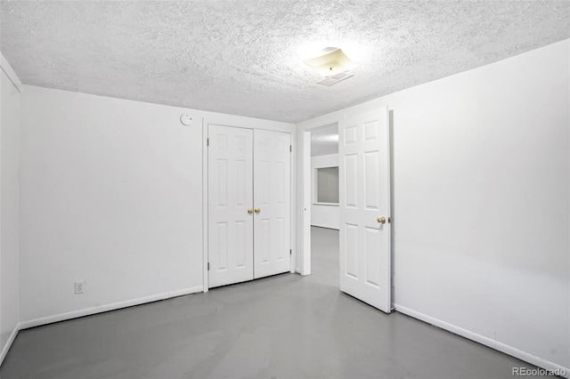 unfurnished bedroom featuring a closet, a textured ceiling, and concrete floors