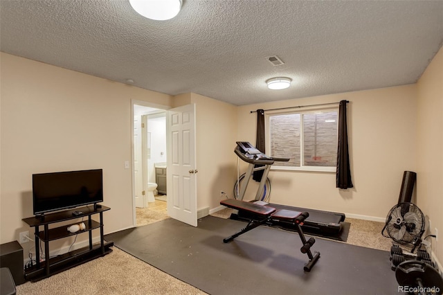 exercise room featuring visible vents, baseboards, and a textured ceiling