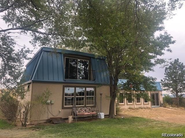 rear view of property featuring a yard