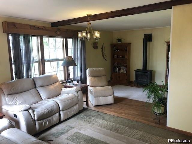 living room featuring a wood stove, beamed ceiling, and wood-type flooring