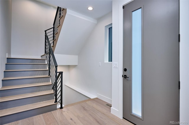 staircase featuring vaulted ceiling and hardwood / wood-style floors