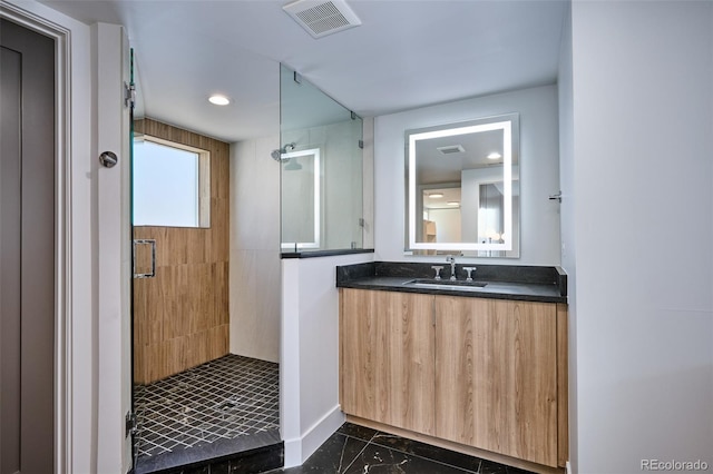 bathroom featuring a tile shower and vanity