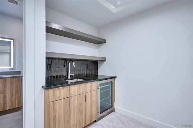 bar featuring beverage cooler, dark stone countertops, light carpet, sink, and backsplash