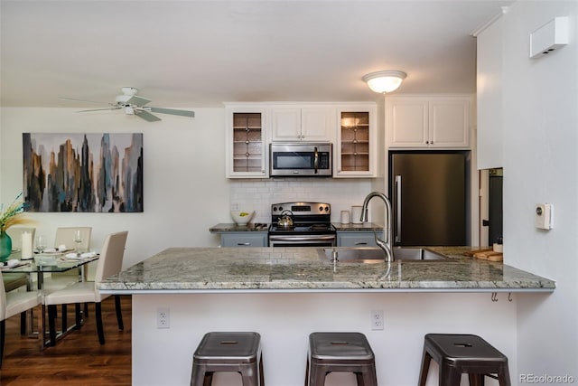 827 Maxwell Ave Unit H, Boulder, CO 80304 - kitchen featuring stainless steel appliances, a sink, backsplash, a breakfast bar, and white cabinets