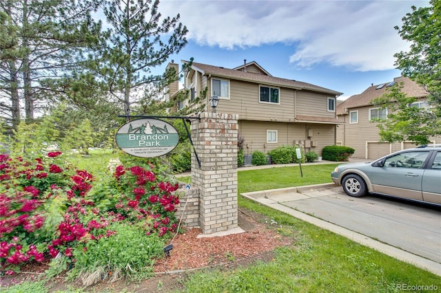 1099 S Walden Way Unit 205, Aurora, CO 80017 - view of property exterior featuring uncovered parking, a yard, and a chimney