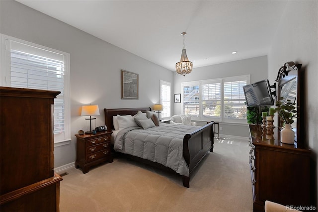 bedroom with a chandelier, light colored carpet, and baseboards