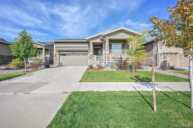 craftsman inspired home featuring driveway, a garage, stone siding, a porch, and a front lawn