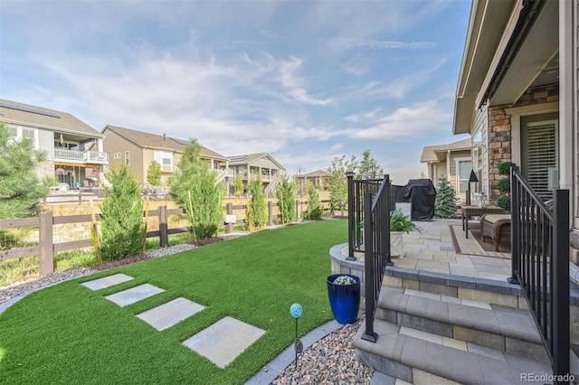 view of yard with a patio, fence, and a residential view