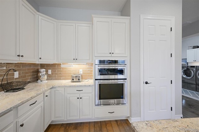 kitchen featuring dark wood-style floors, double oven, white cabinetry, and washer and clothes dryer