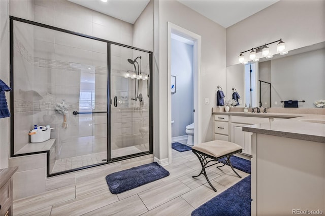 bathroom featuring a stall shower, vanity, and toilet