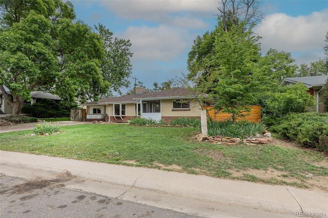 5810 S Greenwood St, Littleton, CO 80120 - view of front of home featuring brick siding, a front lawn, and a chimney
