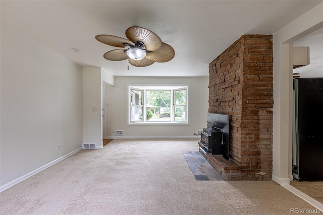 5810 S Greenwood St, Littleton, CO 80120 - unfurnished living room with light colored carpet, a ceiling fan, a wood stove, and baseboards