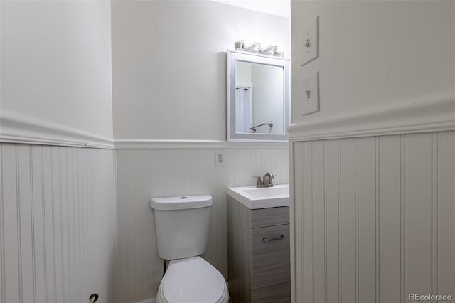 5810 S Greenwood St, Littleton, CO 80120 - half bathroom featuring a wainscoted wall, toilet, and vanity