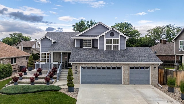 6888 Howell St, Arvada, CO 80004 - view of front of property featuring concrete driveway, brick siding, a shingled roof, and an attached garage