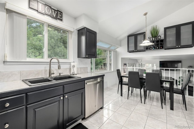 6888 Howell St, Arvada, CO 80004 - kitchen with stainless steel dishwasher, vaulted ceiling, hanging light fixtures, and light tile patterned flooring