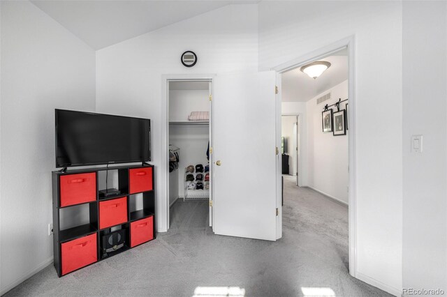 6888 Howell St, Arvada, CO 80004 - unfurnished bedroom featuring a spacious closet, carpet flooring, lofted ceiling, and a closet