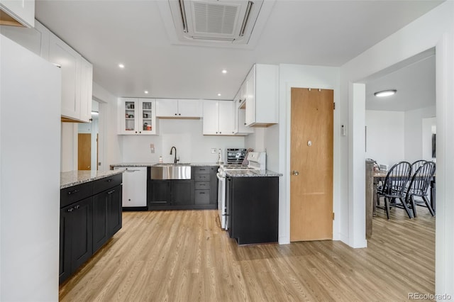 kitchen with sink, dishwasher, white cabinets, light hardwood / wood-style floors, and stainless steel range with electric cooktop