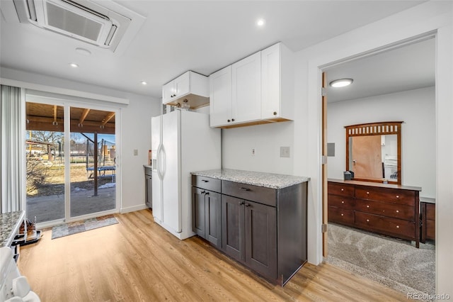 kitchen featuring dark brown cabinetry, white cabinetry, light hardwood / wood-style flooring, and white refrigerator with ice dispenser