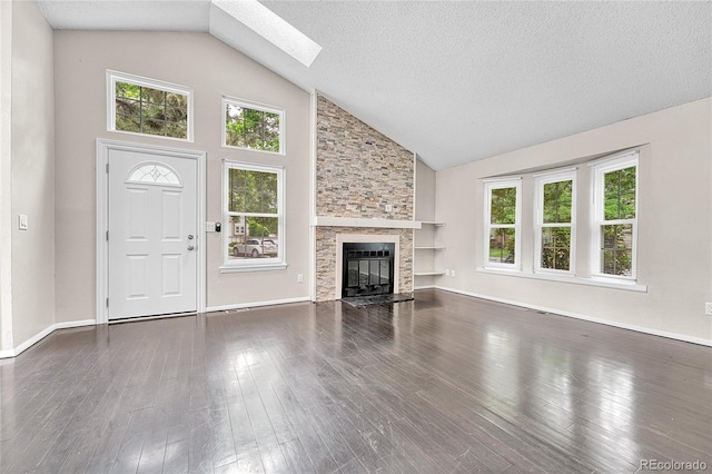 1148 S Ventura Cir Unit H, Aurora, CO 80017 - unfurnished living room featuring healthy amount of natural light, high vaulted ceiling, a skylight, a fireplace, and dark wood finished floors