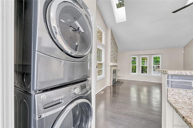 1148 S Ventura Cir Unit H, Aurora, CO 80017 - laundry area featuring stacked washer / dryer, a skylight, wood finished floors, a fireplace, and baseboards