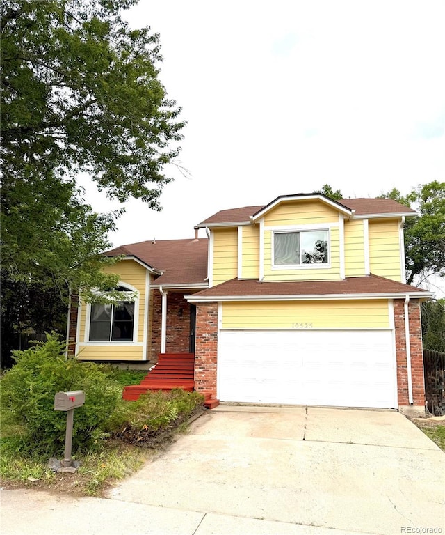 10525 Hobbit Ln, Westminster, CO 80031 - view of front facade with a garage, concrete driveway, and brick siding