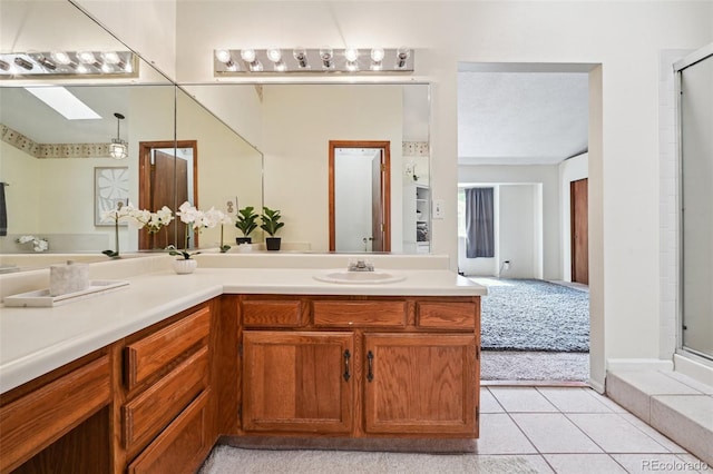10525 Hobbit Ln, Westminster, CO 80031 - full bathroom featuring a skylight, vanity, an enclosed shower, and tile patterned flooring