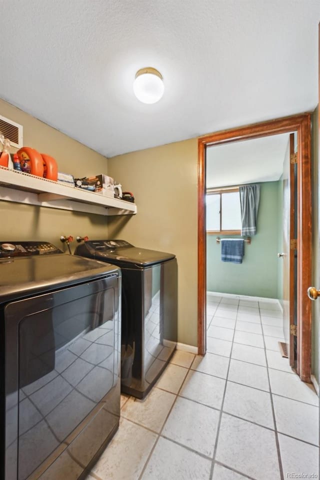 10525 Hobbit Ln, Westminster, CO 80031 - laundry room featuring independent washer and dryer, light tile patterned flooring, and a textured ceiling