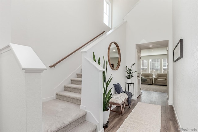 17825 Gallup St, Broomfield, CO 80023 - stairway with wood finished floors, a towering ceiling, and baseboards