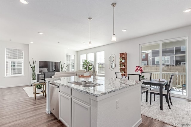 17825 Gallup St, Broomfield, CO 80023 - kitchen featuring a sink, stainless steel dishwasher, dark wood-style flooring, light stone counters, and pendant lighting