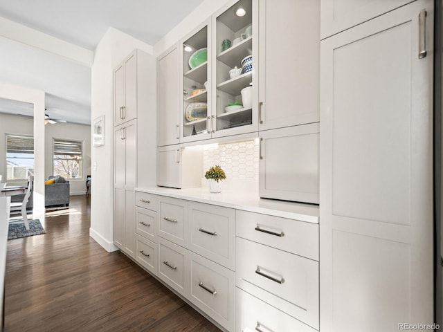 bar featuring white cabinets, ceiling fan, and dark wood-type flooring