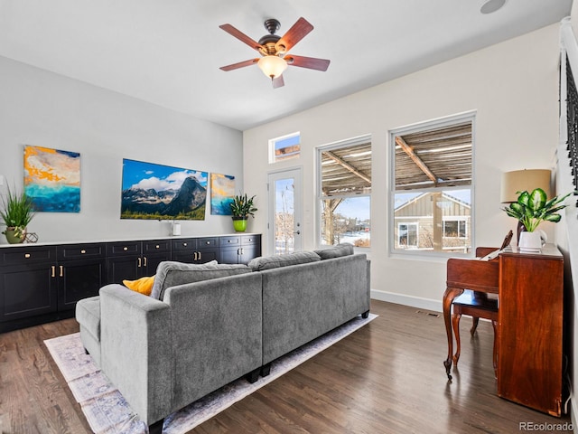 living room featuring ceiling fan and dark hardwood / wood-style flooring