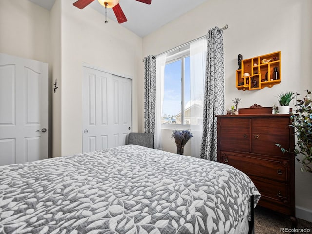 carpeted bedroom with ceiling fan and a closet