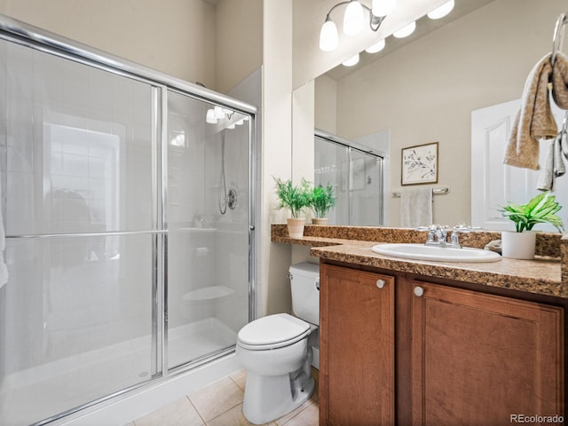 bathroom featuring vanity, toilet, a shower with door, and tile patterned flooring