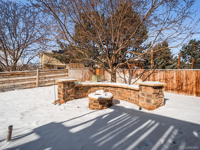 snow covered patio with an outdoor fire pit