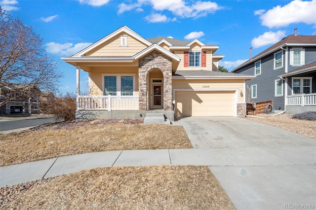 view of front of property featuring stone siding, covered porch, driveway, and an attached garage