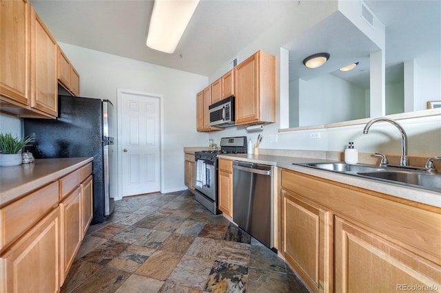 kitchen with stainless steel appliances, light brown cabinets, and sink