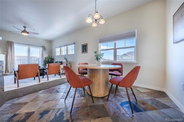 dining area with a textured ceiling and ceiling fan with notable chandelier