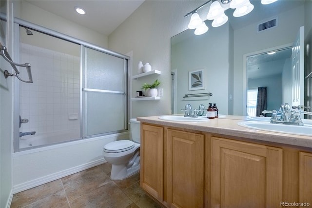 full bathroom featuring toilet, vanity, and shower / bath combination with glass door