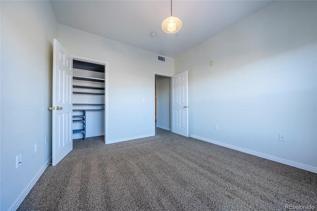 unfurnished bedroom featuring a closet and dark colored carpet