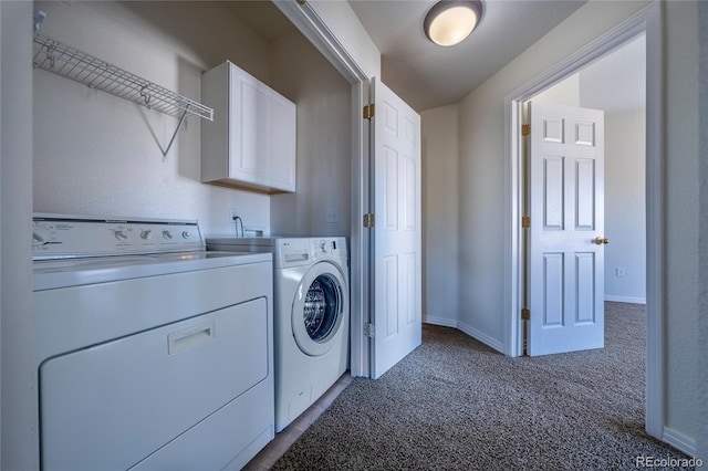 laundry area with carpet floors, washing machine and clothes dryer, and cabinets