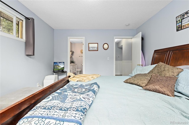 bedroom featuring connected bathroom and a textured ceiling