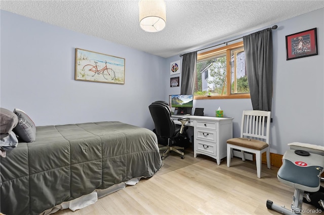 bedroom featuring a textured ceiling and light hardwood / wood-style flooring