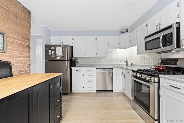 kitchen featuring white cabinets, sink, appliances with stainless steel finishes, and light hardwood / wood-style flooring