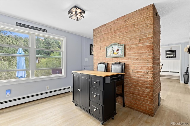 office area featuring a textured ceiling, light hardwood / wood-style floors, and baseboard heating