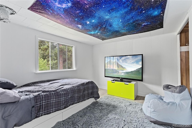 bedroom with hardwood / wood-style flooring and wooden walls