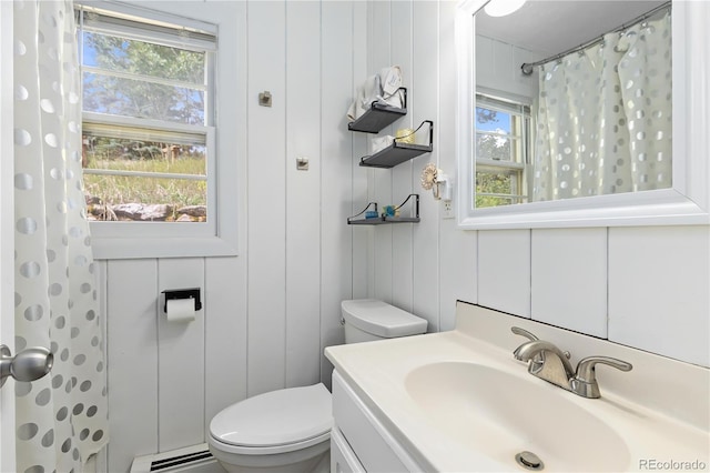 bathroom with baseboard heating, a shower with curtain, vanity, and toilet