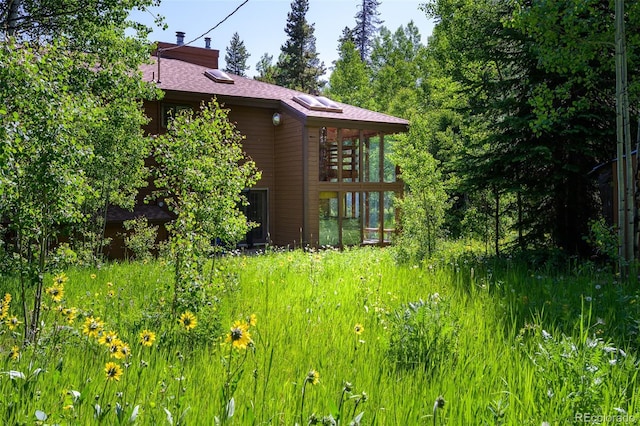 2246 Gcr 8, Fraser, CO 80442 - view of home's exterior with a chimney, a shingled roof, and a sunroom