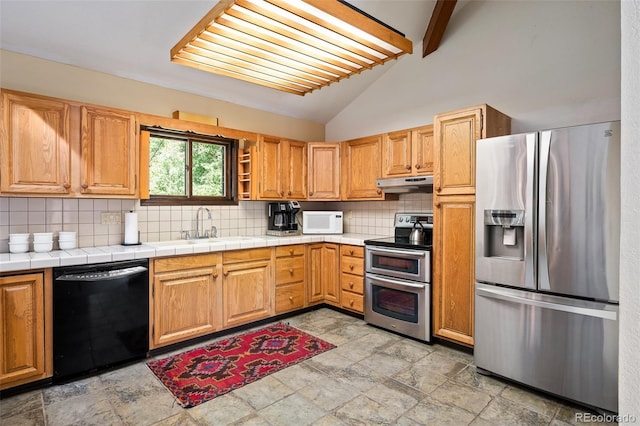 2246 Gcr 8, Fraser, CO 80442 - kitchen featuring stainless steel appliances, decorative backsplash, under cabinet range hood, and light stone finish floors